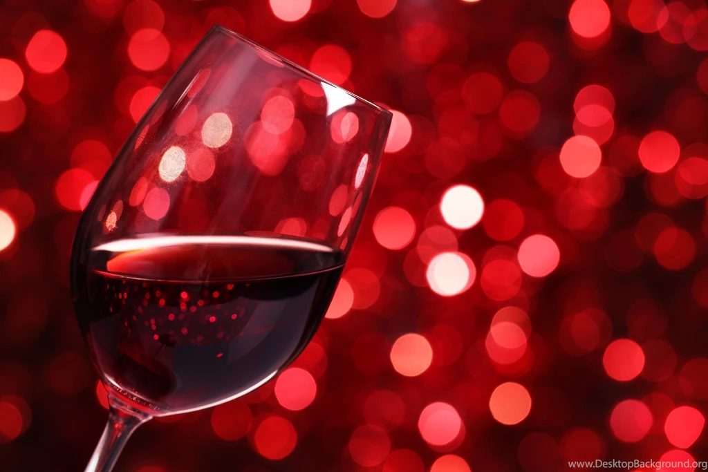 Glass Of Red Wine Against Red Bokeh Backgrounds
