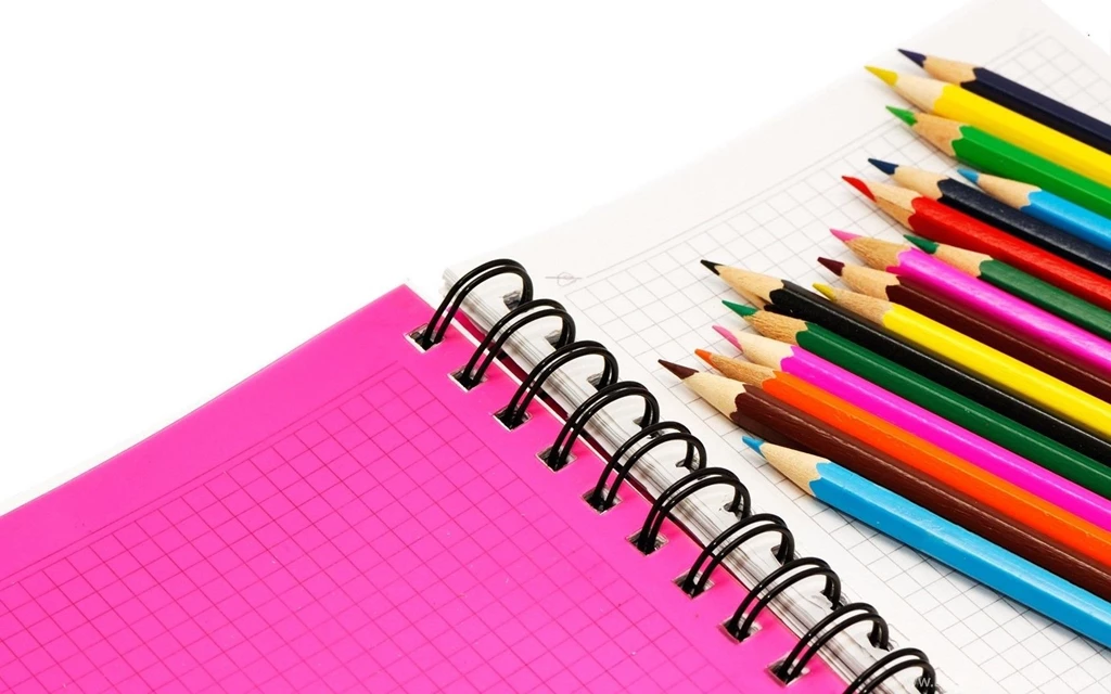 Notebook With Colored Pencils Isolated On White Backgrounds