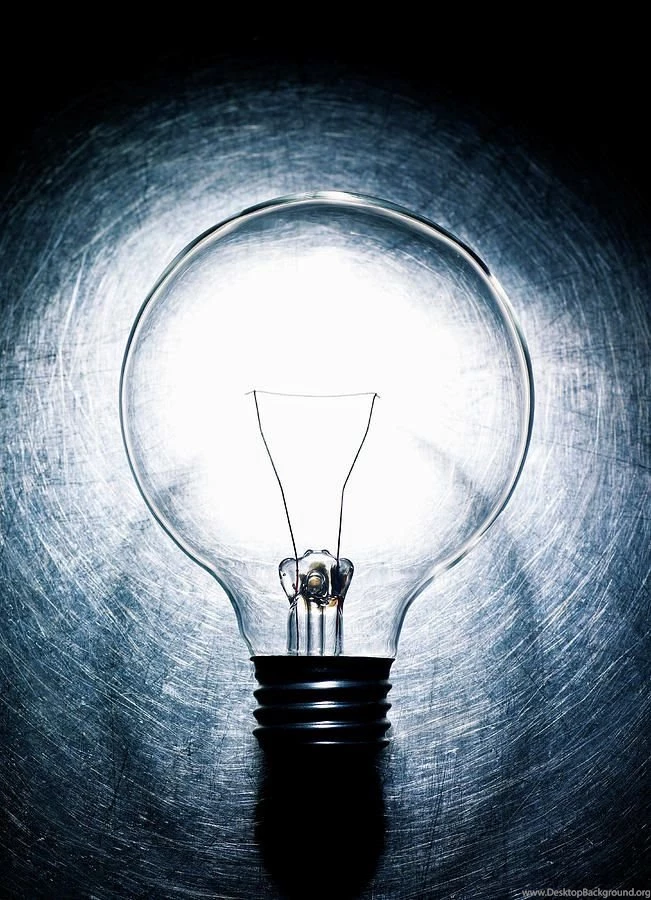 Light Bulb On Stainless Steel Background. Photograph By Ballyscanlon