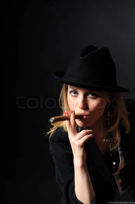 Beautiful Girl In A Hat With A Cigar On A Black Backgrounds