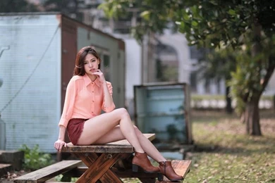 Cute asian girl on a wooden table under a tree 25769.jpg