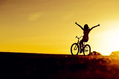 Girl bicycle sunset wide.jpg