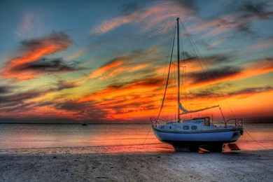 Fishing Boat On The Beach At Sunset