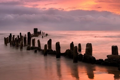 Broken Pier In A Beautiful Peach Colored Sea And Sky   (