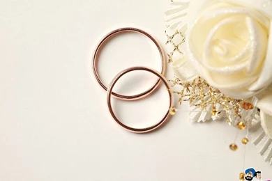 A White Rose With Two Golden Wedding Rings Against A White ...